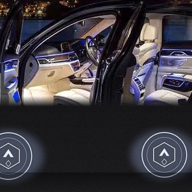 Car doors open at night with StareGang ghost logo projectors casting generic geometric light patterns on the ground